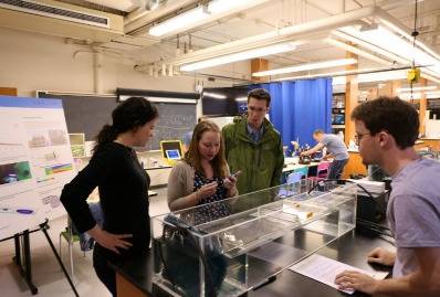 At the 2016 MIT Open House, visitors participate in a hands-on experiment to compare the hydrodynamic performance of different wetland designs chosen by the visitors.